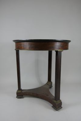 une table ronde avec un plateau en bois et un piètement en métal