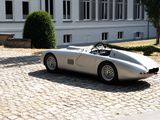 a silver sports car parked on a cobblestone street