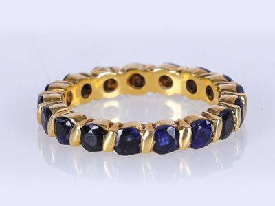 un gros plan sur une bague en or sertie de saphirs bleus