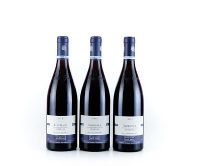 trois bouteilles de vin rouge posées sur une surface blanche