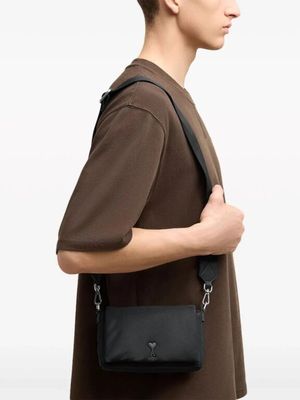 the man is wearing a brown shirt and a black bag