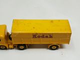 yellow toy truck with a yellow trailer on a white surface