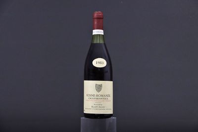 a bottle of wine sitting on top of a table next to a glass