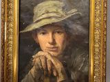 portrait of a woman in a straw hat with her hand on her chin