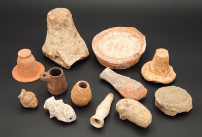 Plusieurs pièces de poterie sont exposées sur un fond noir