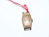 une petite montre-bracelet en or entourée d'un cordon rouge