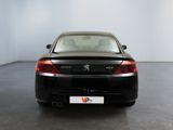 the rear end of a black sports car in a white room