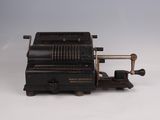 an old typewriter machine sitting on top of a white surface