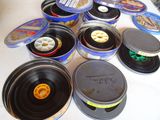 de nombreuses boîtes contenant divers types de disques vinyles, posées sur une table