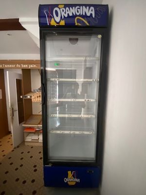 un réfrigérateur qui se trouve dans le coin d'une pièce