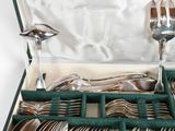 silverware in a green case with spoons, forks and spoons in it