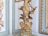 une horloge dorée posée sur une table en bois dans une pièce
