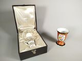 une tasse et une soucoupe dans une boîte, à côté d'une tasse