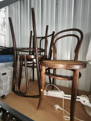 three wooden chairs sitting on a shelf in a room