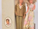 deux poupées qui se tiennent debout ensemble dans une boîte