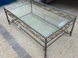 a glass coffee table with a metal frame on it