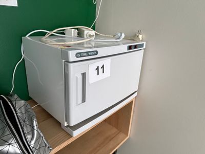 un micro-ondes blanc posé sur une étagère, à côté d'un sac