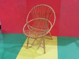 une chaise en osier posée sur un sol jaune et rouge