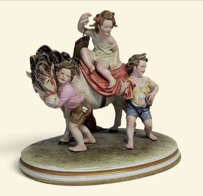 une figurine représentant une femme et deux enfants à cheval