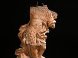 statue d'un homme à cheval, assis sur un rocher dans une pièce sombre