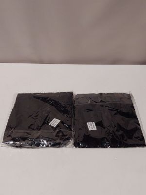 two bags of black plastic sitting on a white table