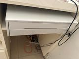 a white computer desk with a drawer underneath it