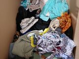 a cardboard box filled with clothes and clothing on the floor