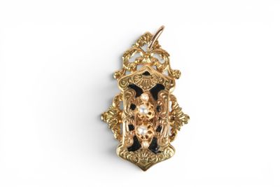 a close up of a gold and black broochle on a white background