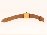 a gold watch with a brown leather strap and a gold buckle