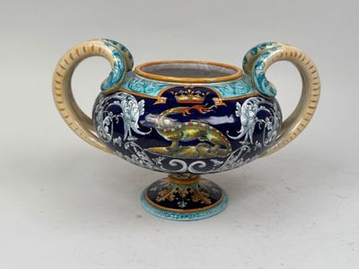 une image représentant un vase bleu et or posé sur une surface blanche