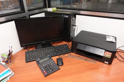 a desk with two computers and a printer on it