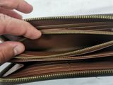 someone is holding a wallet with a small amount of money inside of it