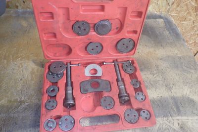 une mallette rouge contenant des outils, posée sur une table