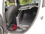 a white truck with a black seat and a red bag in the back of it