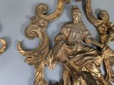 two gold statues of a woman and a man on a wall