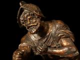 bronze statue of a man with a hat on his head holding a baseball bat