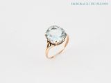 a close up of a gold ring with a blue topaz stone