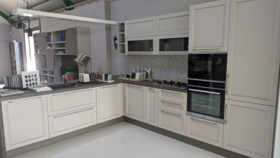 une cuisine avec des placards blancs et une cuisinière-four noire