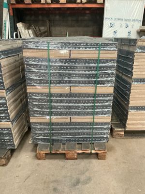 many stacks of metal plates stacked on pallets in a warehouse