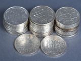 several stacks of silver coins sitting on top of each other on a blue surface