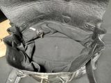 a black purse that is sitting on a chair