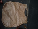 brown leather handbag sitting on the floor next to a pair of shoes