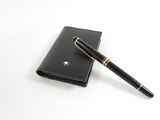 wallet and pen on a white surface