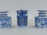 trois vases bleus et blancs avec couvercle, posés sur une surface blanche