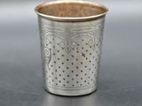 a close up of a silver cup sitting on top of a table