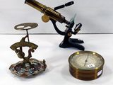 deux types de microscopes et une horloge posés sur une table