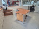 an office with a desk and shelves in the corner