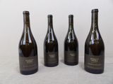four bottles of wine are lined up on a table