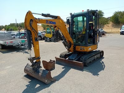 a picture of a small excavator parked in a parking lot