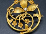 une image représentant une broche en or ornée de fleurs et de feuilles